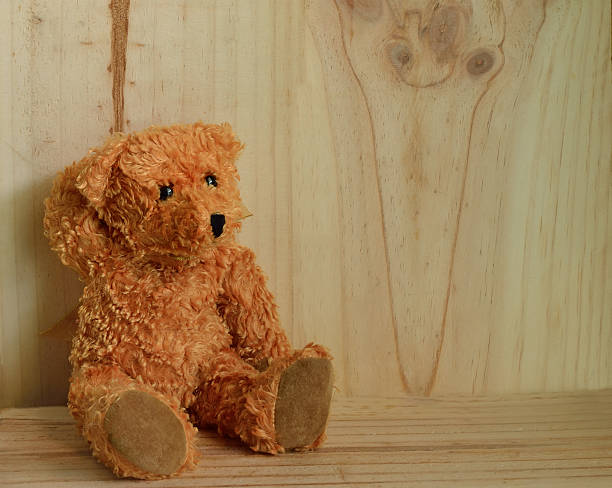 istock Teddy bear sitting on wooden background 493738778