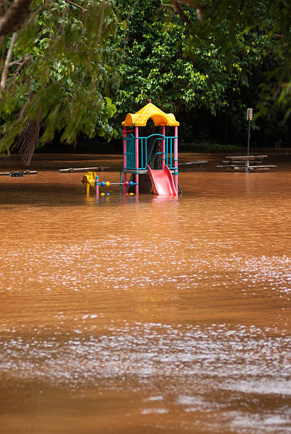 Playground submerged by floodwaters A children's playground half submerged by turbid floodwaters from Freshwater Creek. Taken in Cairns, Australia, following several days of heavy rainfall in Feb 2015.  queensland floods stock pictures, royalty-free photos & images