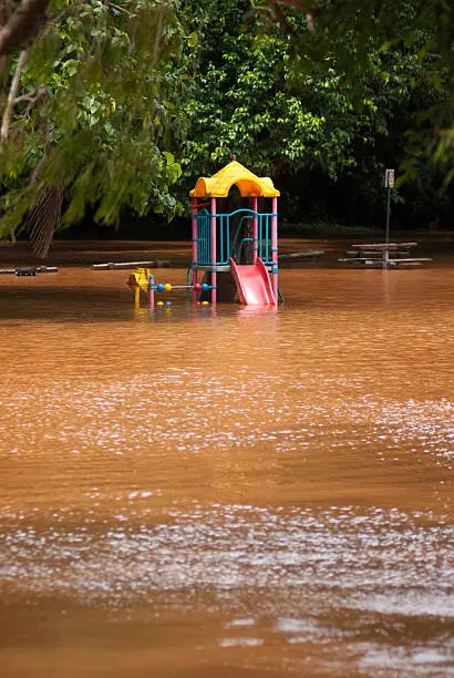 A children's playground half submerged by turbid floodwaters from Freshwater Creek. Taken in Cairns, Australia, following several days of heavy rainfall in Feb 2015. 