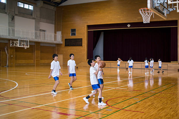 japanische kinder sportarten wie basketball in der sporthalle - school gymnasium gym basketball court school stock-fotos und bilder