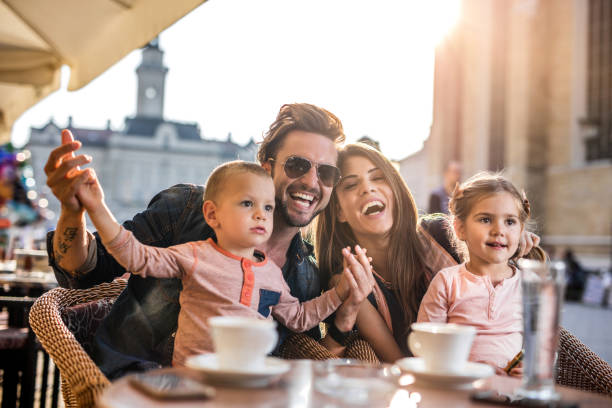 istock Cheerful parents having fun with their small children at cafe. 493743620