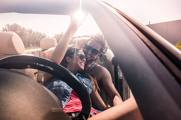 istock Young happy couple having fun together in convertible car. 493745264