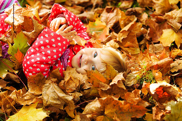 istock cute little girl playing with autumn fall 493745746