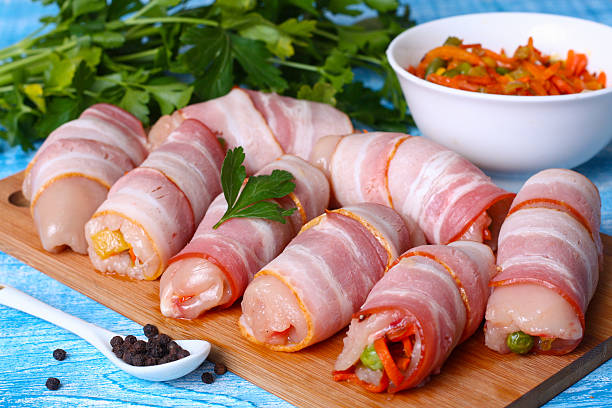 istock Raw chicken rolls stuffed with vegetables wrapped in bacon 493746192