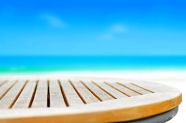 istock Round wood table top on blur blue sea background 493746216