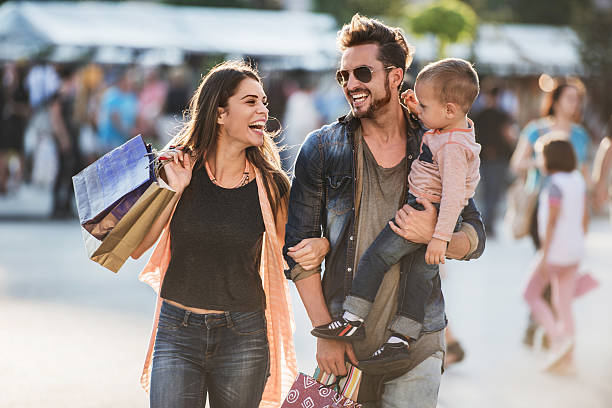 Young happy parents having fun with their son in shopping.