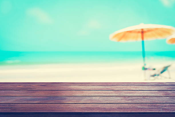 istock Old dark brown wood table top on blurred beach background 493746772