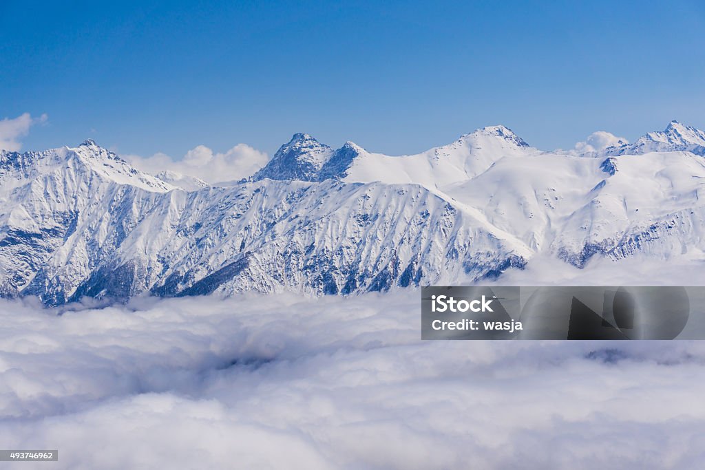 View on mountains and blue sky above clouds, Krasnaya Polyana View on winter snowy mountains and blue sky above clouds, Krasnaya Polyana, Sochi, Russia 2015 Stock Photo