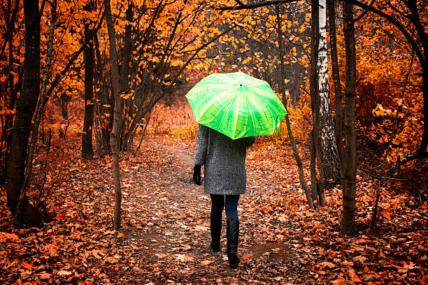istock Young beautiful girl going under umbrella 493747094