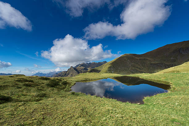 istock Small mountain lake in the middle of meadows 493748718
