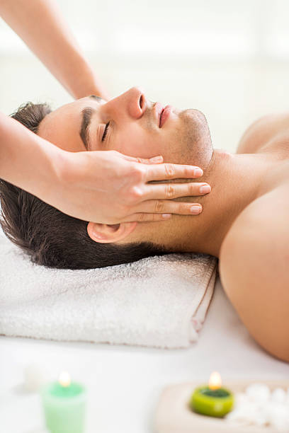 istock Young man getting facial massage at spa. 493749132