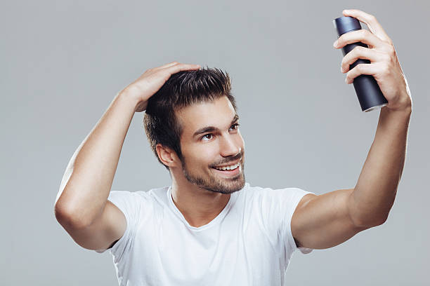 istock Young man applying spray to his hair 493749240