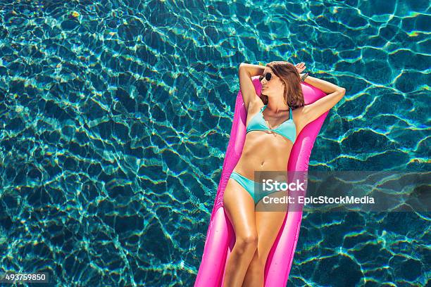 Beautiful Woman Relaxing Floating On Raft In Pool Stock Photo - Download Image Now - 2015, Adult, Adults Only