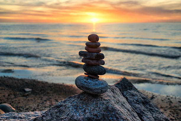 istock Stable vertical cairn at sunset on the sea 493760422