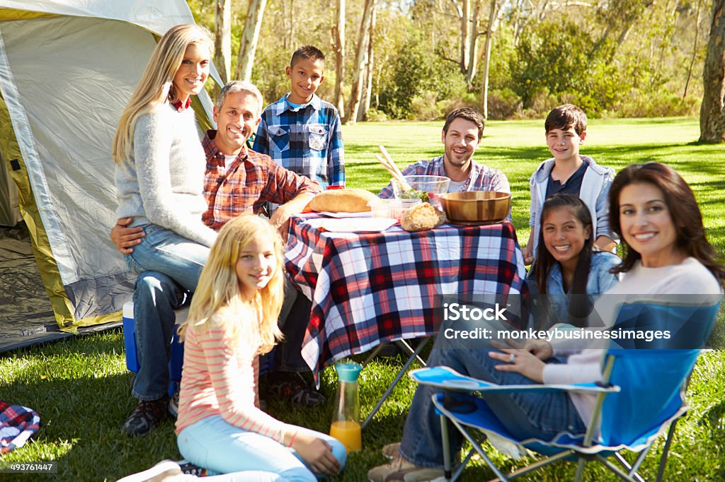 Two Families Enjoying Camping Holiday In Countryside Two Families Enjoying Camping Holiday In Countryside Smiling To Camera 10-11 Years Stock Photo