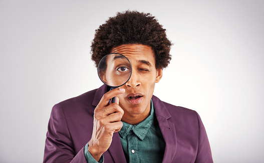 Studio shot of a young man using a magnifying glass against a gray backgroundhttp://195.154.178.81/DATA/i_collage/pu/shoots/805791.jpg