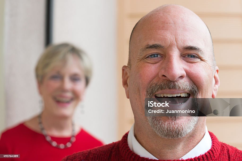 Smiling mature couple Smiling mature caucasian man posing with his wife in the background 50-59 Years Stock Photo