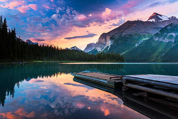 Dawn at Maligne Lake Early morning from the shore of Fisherman's Bay Campground on Maligne Lake, in the Canadian Rockies. This wilderness campground is only accessible by canoe or kayak and is situated in one of North America's most pristine landscapes. jasper national park stock pictures, royalty-free photos & images