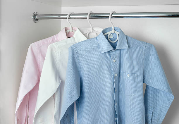 white, blue and pink clean ironed men's shirts stock photo