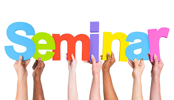 istock Multiethnic Arms Raised Holding Text Seminar 493768515
