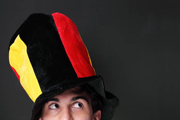 Football fan standing arms crossed in front of his friends, celebrating.