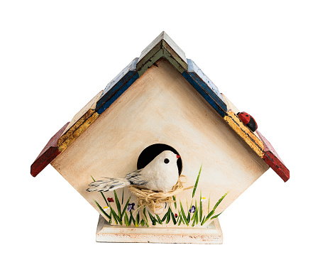 Hand made birdhouse with bird, grass and flowers painted on walls, isolated on white