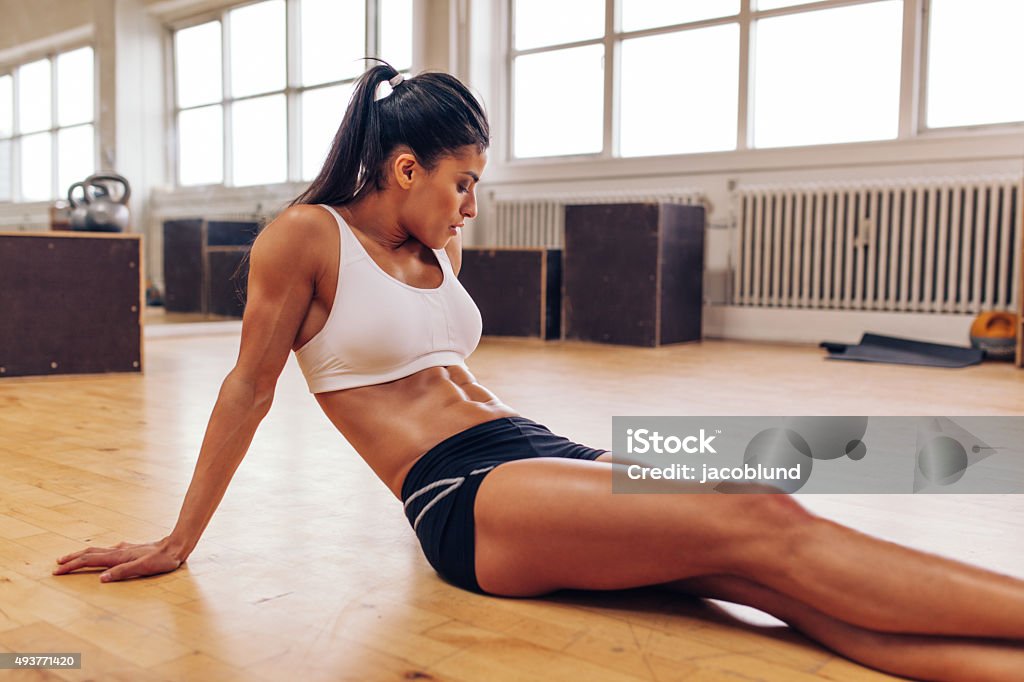 Woman relaxing after workout at gym Portrait of muscular young woman relaxing after workout at gym. Fit female athlete taking a break from workout. 20-29 Years Stock Photo