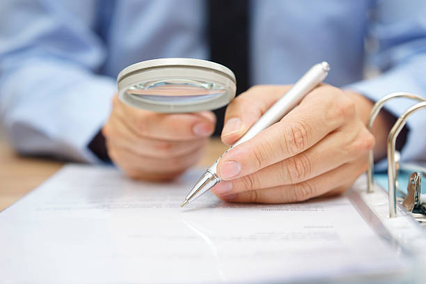 istock businessman is analyzing  through  magnifying glass contract and prices 493771626