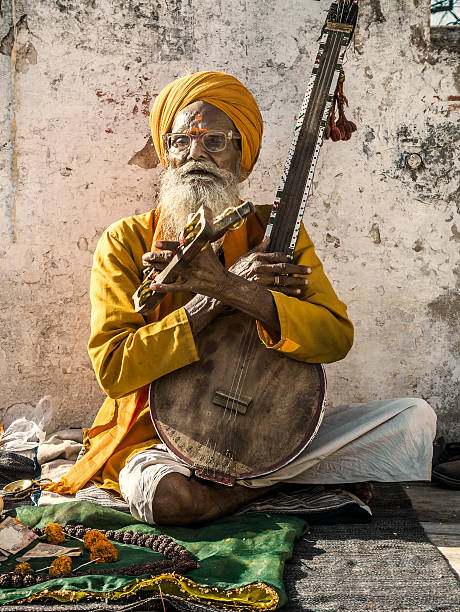 Udaipur, India - September 25, 2015: Senior musician playing music and singing at the entrance of the Jagdish temple in Udaipur India.