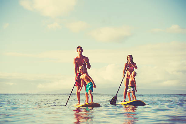 famiglia alzarsi pagaiare - surfing beach family father foto e immagini stock