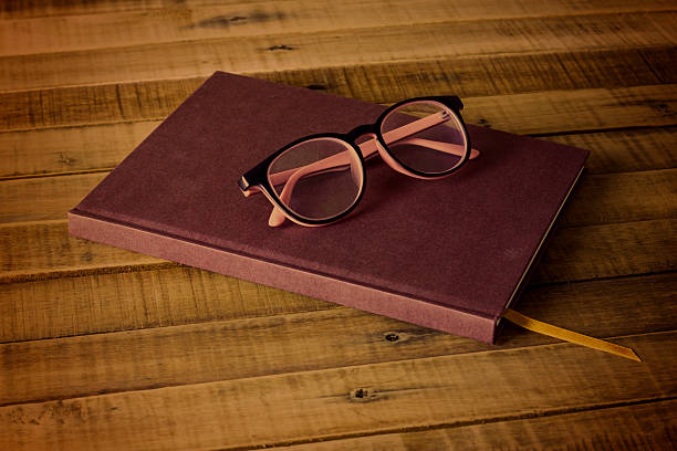 istock book with glasses  on the wooden background 493784152