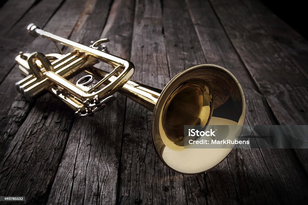 Trumpet on an old wooden table Trumpet Stock Photo