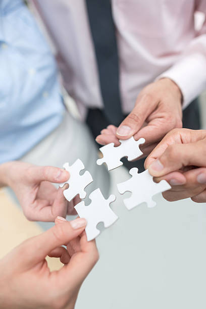 istock Business people assembling pieces of a puzzle 493786918