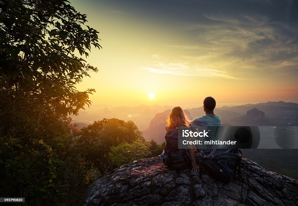 Hikers Two hikers on top of the mountain enjoying sunrise over the tropical valley Couple - Relationship Stock Photo