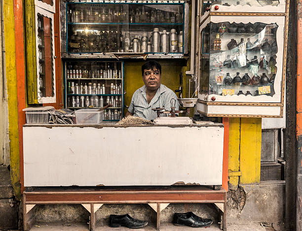 Jodhpur, India - September 25, 2015: Shop vendor selling perfumes and scents in little market stall in Jodhpur Rajasthan India. With more than 1 million people it is the second largest city in Rajasthan. Known as the blue city because the many blue painted houses it is a main tourist destiny.