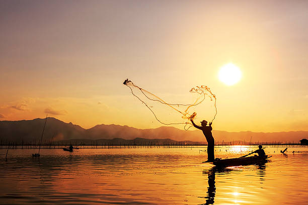 istock throwing fishing net during sunset 493796479