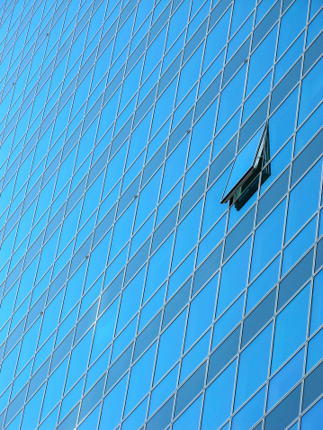 Windows on a modern building. Only one is open.