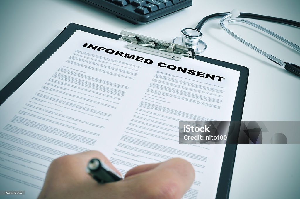 signing an informed consent patient signing an informed consent in a doctors office Permission - Concept Stock Photo