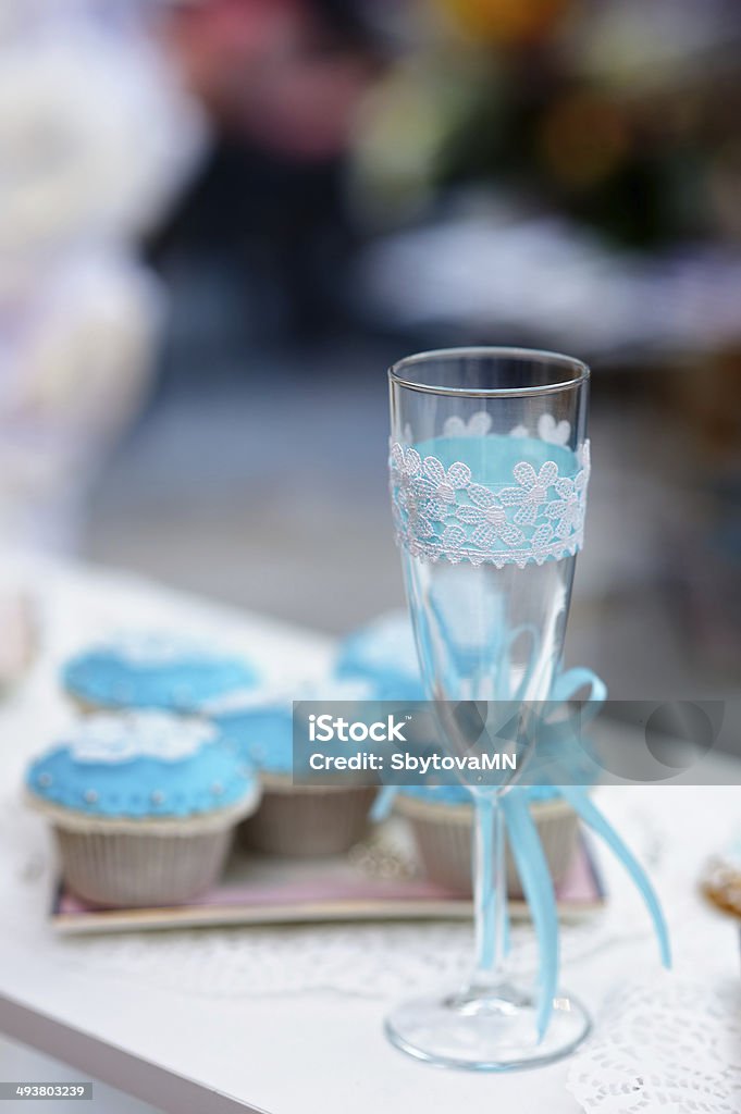 Stylish champagne glass Stylish champagne glass and blue cupcakes Alcohol - Drink Stock Photo