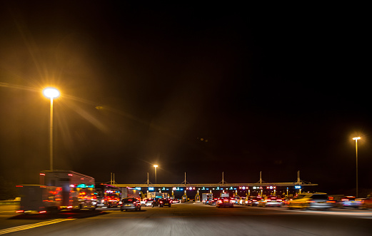 Avonmouth, UK - October 22, 2015: Toll booth plaza on the Westbound Severn Bridge. Cars and vans queuing to cross from England into Wales on the M4 motorway at night