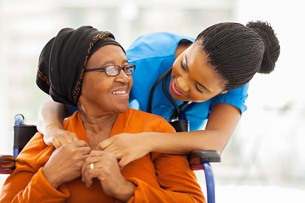 african senior patient with female nurse happy senior patient with friendly female nurse wheelchair photos stock pictures, royalty-free photos & images