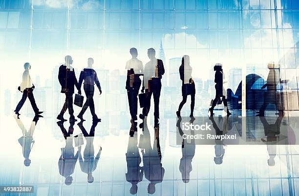 Silhouettes Of Business People Walking Inside The Office Stock Photo - Download Image Now