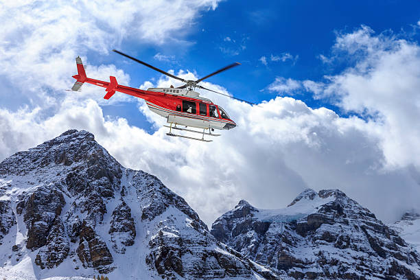 Helicopter at Assiniboine Lodge and Magog Lake Mount Assiniboine Provincial Park was established 1922. Some of the more recent history that is explorable within the park include Wheeler's Wonder Lodge (Naiset) (1924), Assiniboine Lodge (1928), the first ski lodge in the Canadian Rockies and Sunburst (1928). Mount Assiniboine on the background. lake magog photos stock pictures, royalty-free photos & images