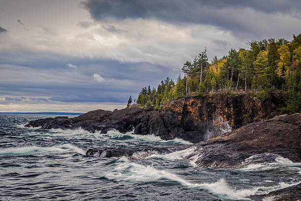 Moody gray sky over a storm and wavy Lake Superior shore. Lake Superior is the largest of the Great Lakes and is known for it's ferocious gales in the autumn. This seascape was shot in Presque Isle Park located in Marquette, Michigan.