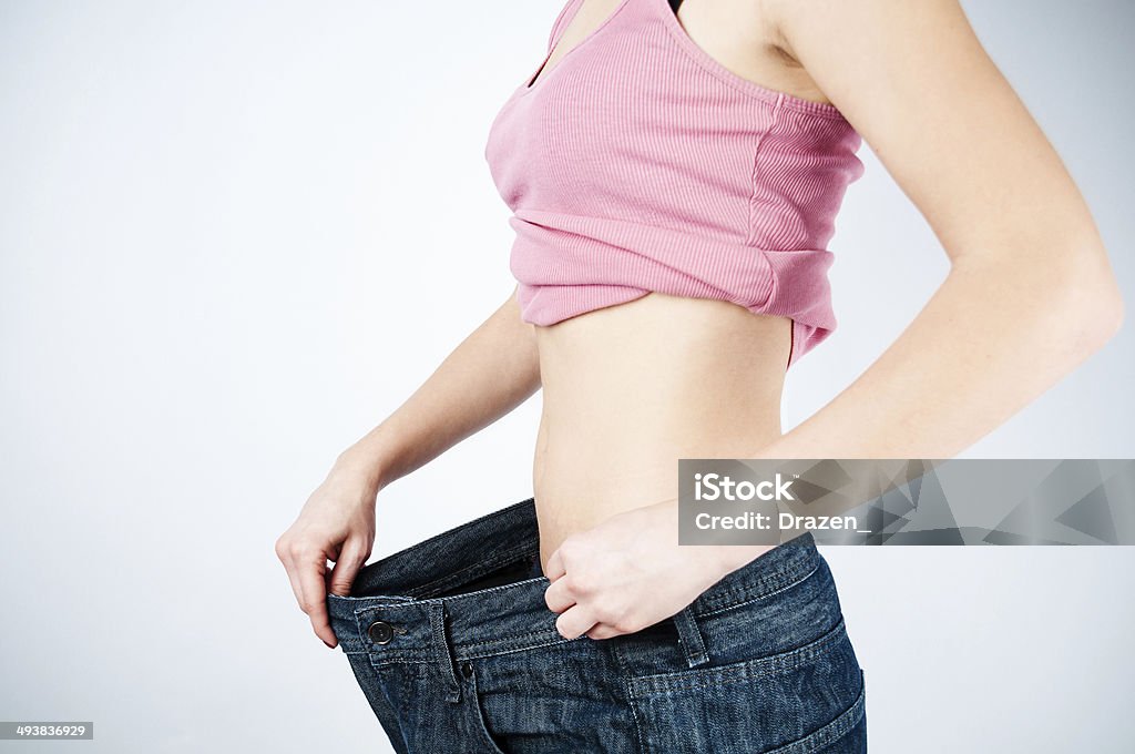 Diet Unrecognizable woman showing large trousers and flat stomach Abdominal Muscle Stock Photo