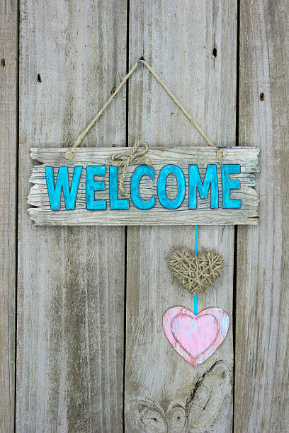 istock Welcome sign with hearts hanging on wood background 493838446