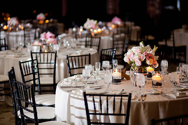 Tables with centerpieces at wedding reception Multiple tables with centerpieces at an indoor elegant wedding reception black tie events stock pictures, royalty-free photos & images
