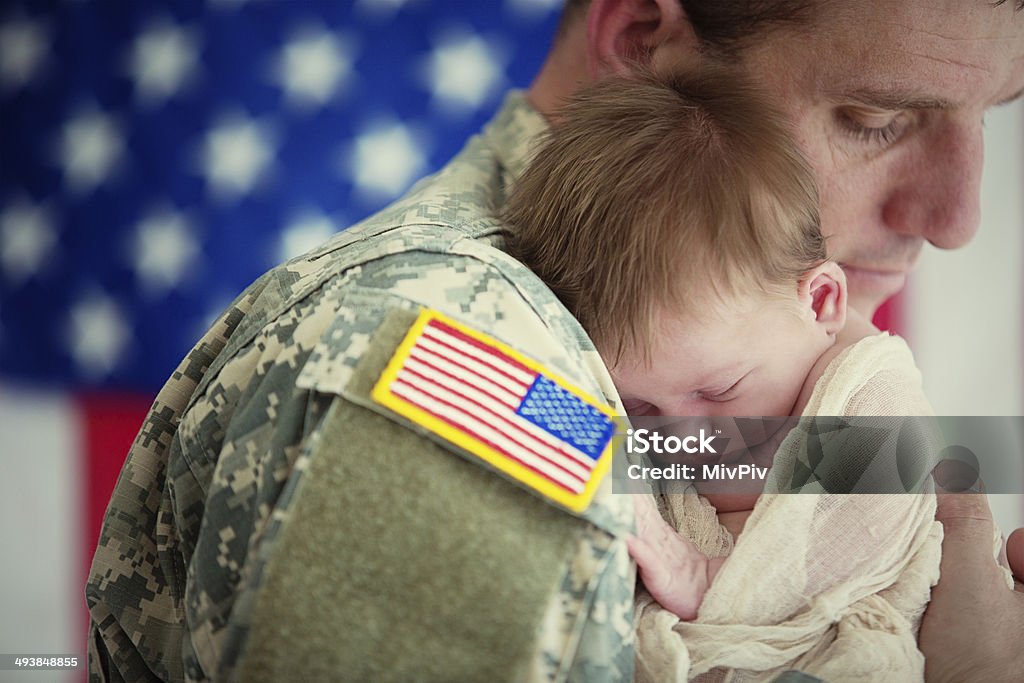 American soldier holding newborn baby Soldier in uniform holding a newborn baby Military Stock Photo