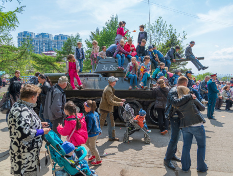 Vladivostok, Russia - May 9, 2014: Children and adult play on restored T-34 medium tank during festivities devoted to Victory Day.