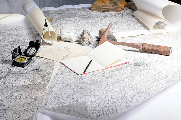 geological expedition The geological expedition is prepared with the study of topographic maps. On the table the tools of the geologist. geologist stock pictures, royalty-free photos & images